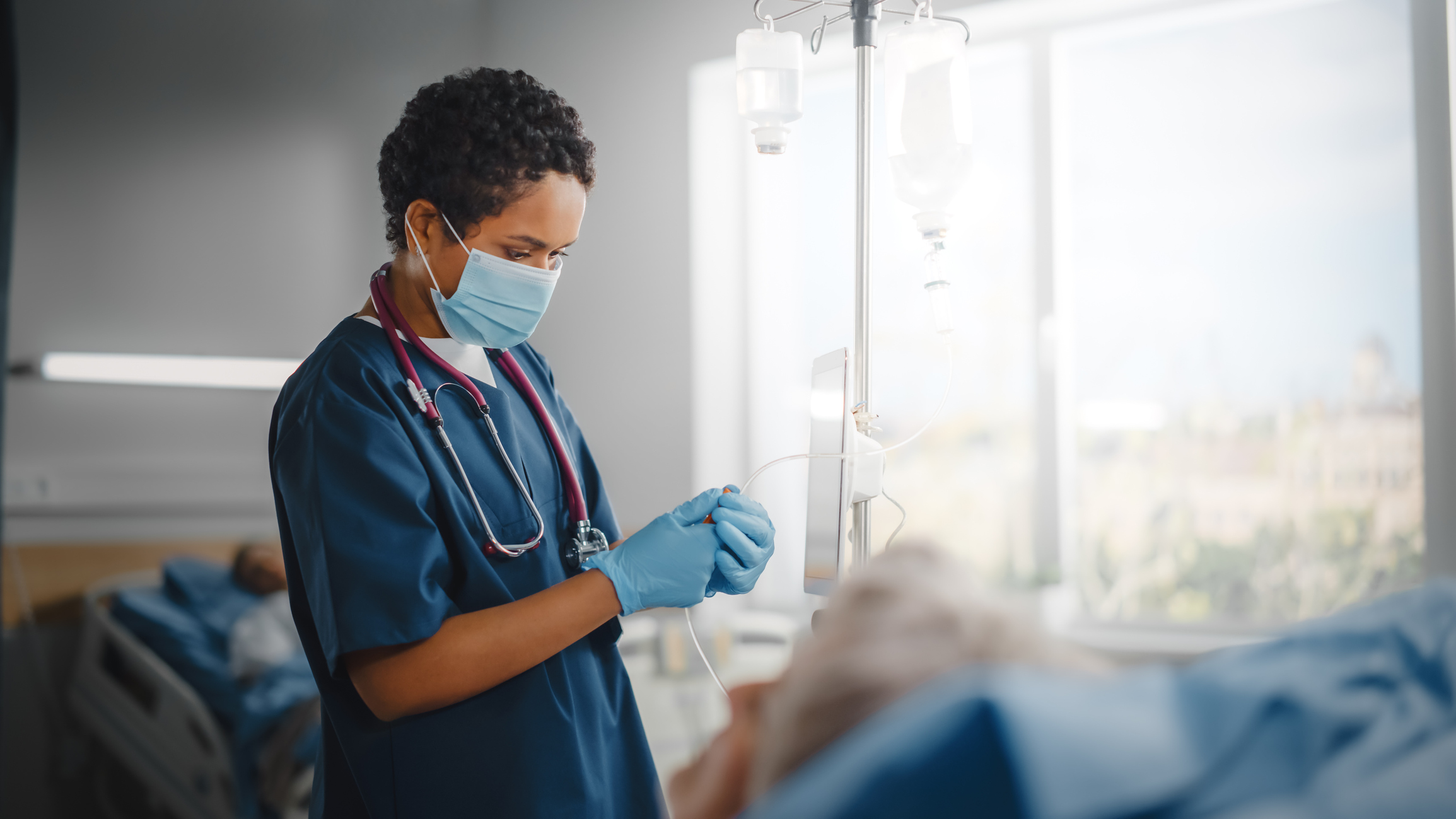 Travel Nurse hooking up a patients IV Travel Nurse hooking up a patients IV