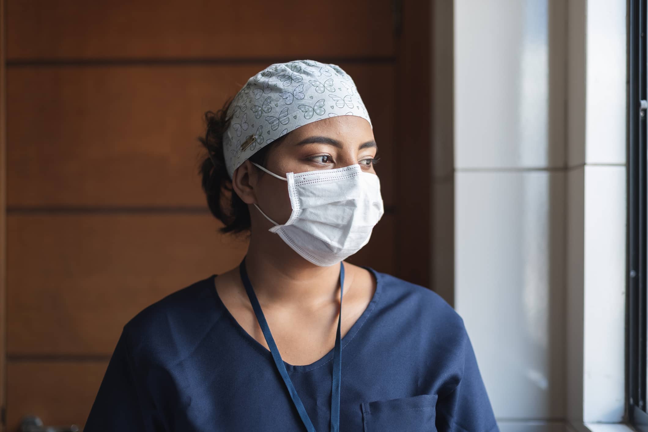 Fatigued travel nurse looking out window Fatigued travel nurse looking out window
