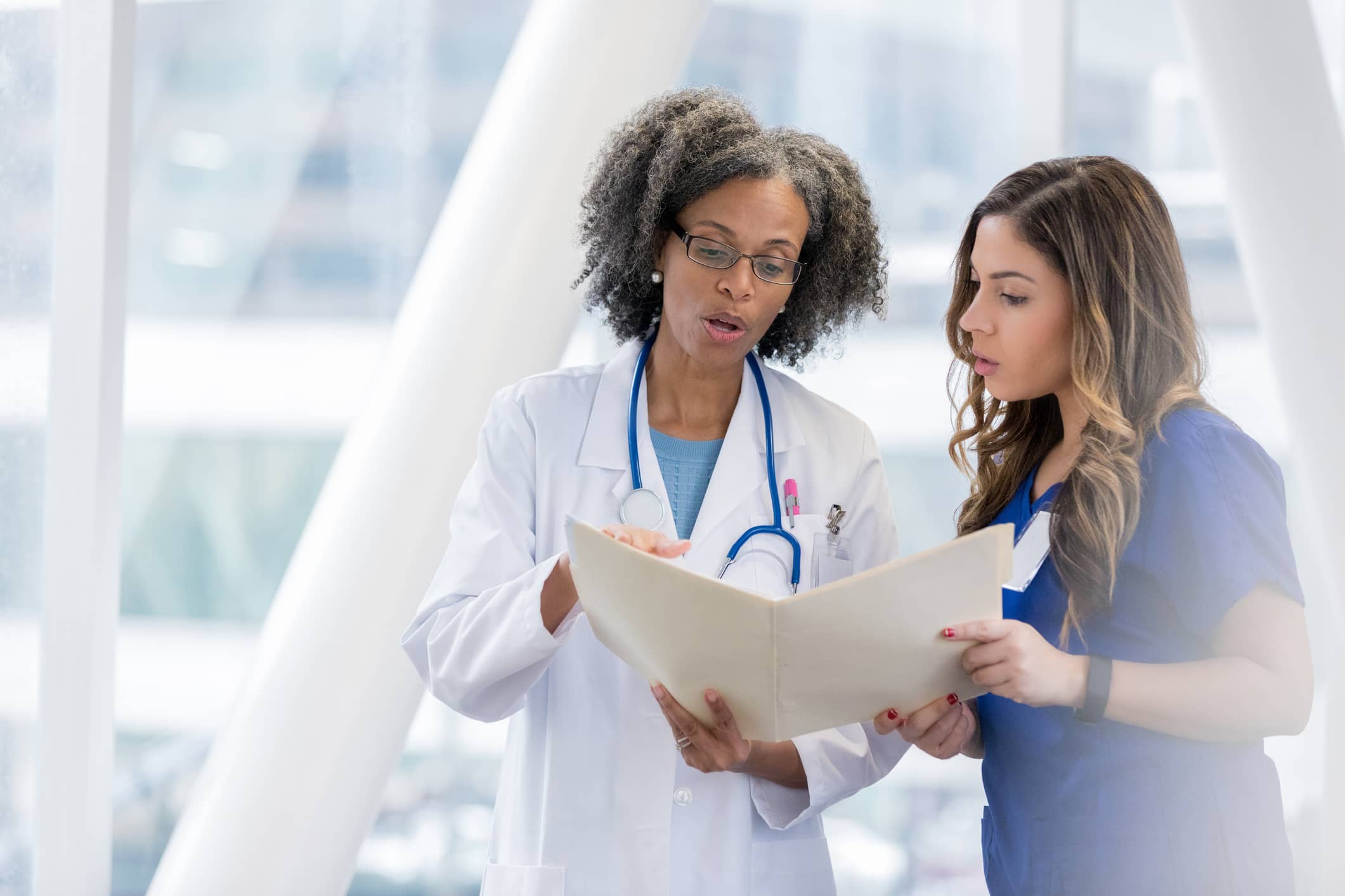 Travel nurse reviewing a patient's file with a doctor
